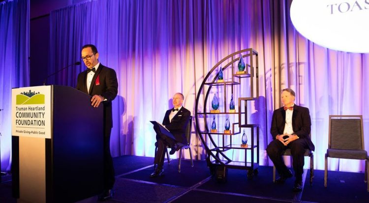 three men on a stage at the gala