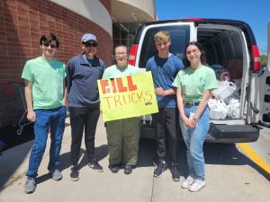 Students stand in front of van full of donated items