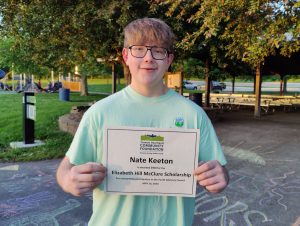 student holding his scholarship certificate