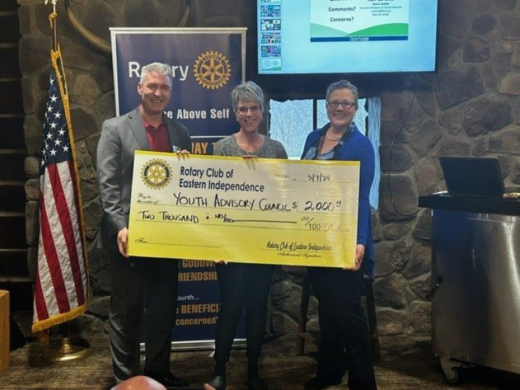 Independence Rotary president presents large check to two THCF staff members